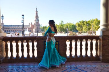 Genç ve güzel dansçı bir fotoğraf çekiminde kameraya poz veriyor. Kadın çok güzel ve geleneksel kıyafetler giyiyor. Güzellik, folklor ve göbek dansı konsepti.