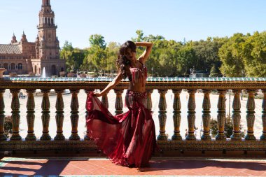 Genç ve güzel dansçı bir fotoğraf çekiminde kameraya poz veriyor. Kadın çok güzel ve geleneksel kıyafetler giyiyor. Güzellik, folklor ve göbek dansı konsepti.