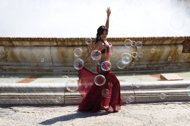 Meydanda dans eden genç ve güzel bir dansçı. O, elinde beyaz bir peçeyle açık mavi giyinmiş. Afrika ve Asya 'dan gelen dünya folklor kavramı.