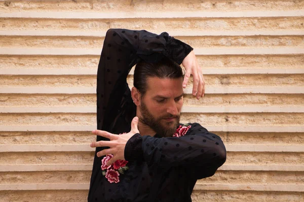 Siyah gömlekli ve kırmızı güllü bir adamın portresi, kahverengi arka planda farklı pozlar veriyor. Flamenko dans konsepti insanlığın kültürel mirası. Tutku