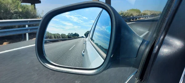 后视镜的车 你可以看到蓝天和白云 你也可以看到道路 — 图库照片