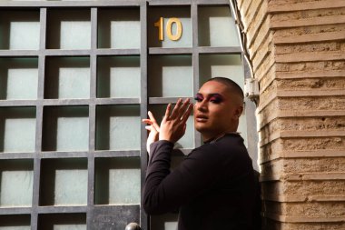 İkili olmayan, Güney Amerika kökenli ve genç bir kişi, makyaj sanatçısı ve Avrupa 'da seyahat ederken fotoğraflar için poz veriyor. Eşitlik kavramı, homoseksüellik, gey, lezbiyen, transseksüel, gey gururu.