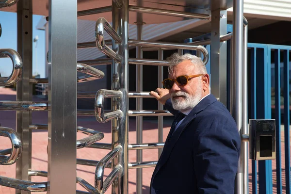 İş adamı ve yönetici olarak çalıştığı binaya sakallı, ceketli, kravatlı ve güneş gözlüklü olgun bir adam giriyor. Konsept patronu, yönetici, ofis, iş ve finans.