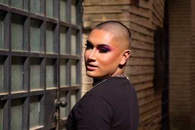 İkili olmayan, Güney Amerika kökenli ve genç bir kişi, makyaj sanatçısı ve Avrupa 'da seyahat ederken fotoğraflar için poz veriyor. Eşitlik kavramı, homoseksüellik, gey, lezbiyen, transseksüel, gey gururu.