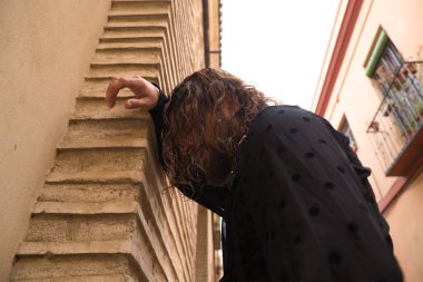 Uzun saçlı, siyah gömlekli ve kırmızı güllü flamenko dansı yapan bir adam kafasını Seville 'in tipik dar bir sokağının duvarına yaslar. Hayal kırıklığı, depresyon, üzüntü, iktidarsızlık, acı, tutku.