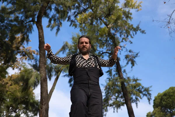 Uzun saçlı çingene adam Seville 'deki bir parkta açık hava sahnesinde flamenko yapıyor ve farklı pozlar veriyor. Flamenko dans konsepti insanlığın kültürel mirası.