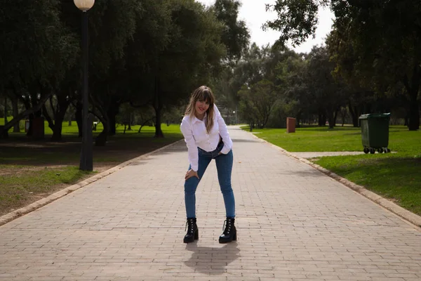 Güzel, sarışın, genç bir kadın farklı pozlar ve vücut ifadeleri veren bir model gibi davranıyor. Kadın, şehirde tatilde. Seyahat ve tatil konsepti, güzellik ve moda.