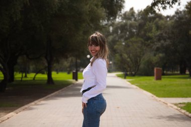 Güzel, sarışın, genç bir kadın farklı pozlar ve vücut ifadeleri veren bir model gibi davranıyor. Kadın, şehirde tatilde. Seyahat ve tatil konsepti, güzellik ve moda.