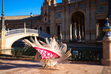 Flamenko dansçısı, kadın, esmer ve güzel tipik İspanyol dansçı Sevilla meydanında kırmızı bir manila şalıyla dans ediyor. İnsanlığın kültürel mirası Flamenko kavramı.