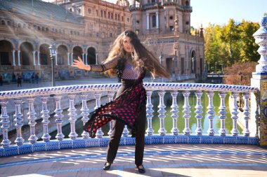 Genç ve güzel tipik İspanyol kadın flamenko yapıyor. Şehir ve modern kıyafetlerle. Saçları açık ve uzun. İnsanlığın Flamenko kültürel mirası kavramı.