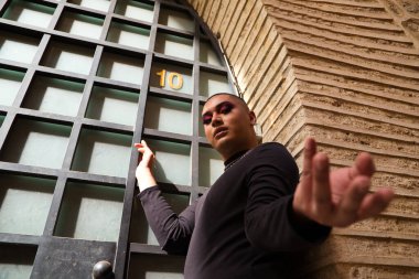 İkili olmayan, Güney Amerika kökenli ve genç bir kişi, makyaj sanatçısı ve Avrupa 'da seyahat ederken fotoğraflar için poz veriyor. Eşitlik kavramı, homoseksüellik, gey, lezbiyen, transseksüel, gey gururu.