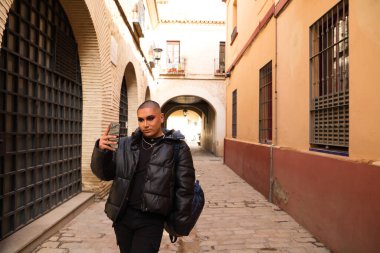 İkili olmayan ve Güney Amerikalı genç insan Avrupa 'da tatilde. Makyaj yapıyor ve siyah elbiseler giyiyor. Şehri ziyaret ediyor ve cep telefonuyla fotoğraf çekiyor. Seyahat.