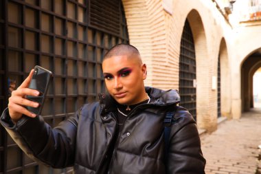 İkili olmayan ve Güney Amerikalı genç insan Avrupa 'da tatilde. Makyaj yapıyor ve siyah elbiseler giyiyor. Şehri ziyaret ediyor ve cep telefonuyla fotoğraf çekiyor. Seyahat.