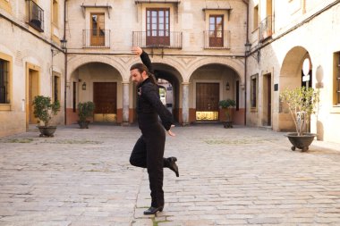 İspanya, Seville 'de sütunları ve balkonları olan bir meydanda uzun saçlı flamenko dansı yapan orta yaşlı bir flamenko. Tutkuyu hisset. Flamenko dans konsepti insanlığın kültürel mirası.