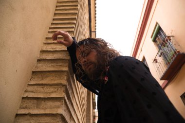 Uzun saçlı, siyah gömlekli ve kırmızı güllü flamenko dansı yapan bir adam kafasını Seville 'in tipik dar bir sokağının duvarına yaslar. Hayal kırıklığı, depresyon, üzüntü, iktidarsızlık, acı, tutku.