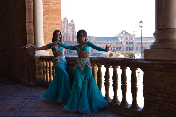 two belly dancers dancing in the place in seville, The dancers are young and beautiful and they are wearing the typical belly dance costume. Concept of dance and regional folklore.