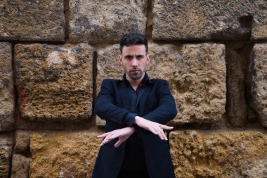 Çingene adam flamenko yapıyor, siyah ve kırmızı ayakkabılar giymiş genç ve yakışıklı taş bir duvarın arkasında poz veriyor ve dans ediyor. İnsanlığın Flamenko kültürel mirası.