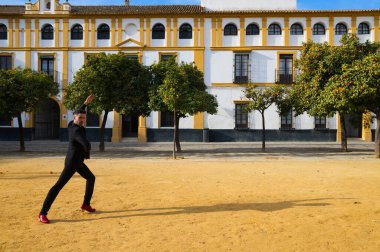 Çingene adam flamenko yapıyor, siyah ve kırmızı ayakkabılar giyip Seville şehrinde portakal ağaçları arasında dans ediyor. İnsanlığın Flamenko kültürel mirası.