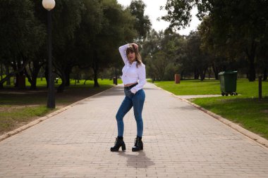 Güzel, sarışın, genç bir kadın farklı pozlar ve vücut ifadeleri veren bir model gibi davranıyor. Kadın, şehirde tatilde. Seyahat ve tatil konsepti, güzellik ve moda.