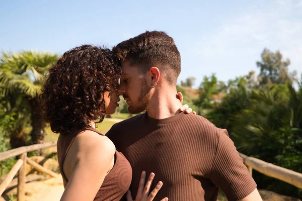 Handsome young man and woman dancing bachata and salsa in the park. The couple dance passionately surrounded by greenery. Dancing concept.