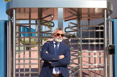 Yakışıklı, olgun, sakallı, ceketli, kravatlı ve güneş gözlüklü adam üniversite kampüsünde öğretim görevlisi olarak çalışıyor. Kavram profesörü, üniversite rektörü..