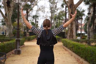 Uzun saçlı ve sakallı, flamenko dansı yapan yakışıklı orta yaşlı bir adam parkta farklı pozlar vererek tutkuyla dans ediyordu. Flamenko, dans, dans, kültür, turizm ve sanat kavramı.