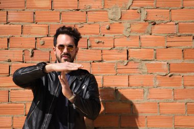 Genç, yakışıklı, esmer, sakallı ve heykel gibi vücudu olan yakışıklı bir adam ölü zamanı işaret ediyor. Durdurma zamanı, dinlenme, rahatlama, stres, fiziksel ve ahlaki yorgunluk kavramı.