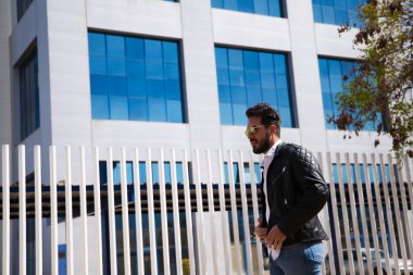 Sakallı, heykel gibi vücudu olan yakışıklı genç bir adam. Ofis müdürü olarak çalıştığı binaya gelmeden önce parkta yürüyordu. Çalışma ve yönetim kavramı.