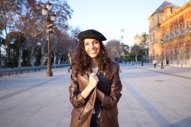 Kıvırcık kahverengi saçlı, siyah şapkalı, deri ceketli, kot pantolonlu ve beyaz çizmeli güzel bir kadın. O, şehri geziyor. Dünya çapında tatil ve turizm kavramı.