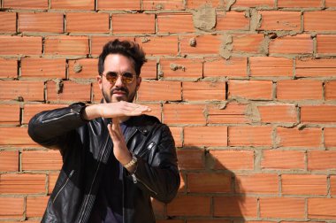 Genç, yakışıklı, esmer, sakallı ve heykel gibi vücudu olan yakışıklı bir adam ölü zamanı işaret ediyor. Durdurma zamanı, dinlenme, rahatlama, stres, fiziksel ve ahlaki yorgunluk kavramı.