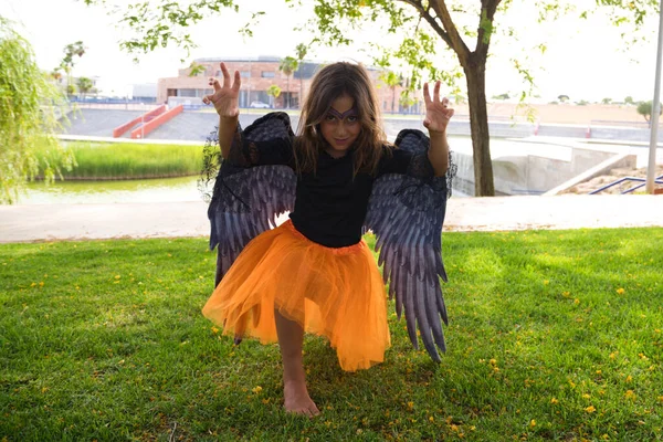 Little Girl Dressed Witch Orange Skirt Black Wings Scares Camera — Stockfoto
