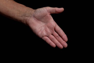 Siyah bir arka planda izole edilmiş yaşlı bir adamın uzanmış selamlama eli.. 