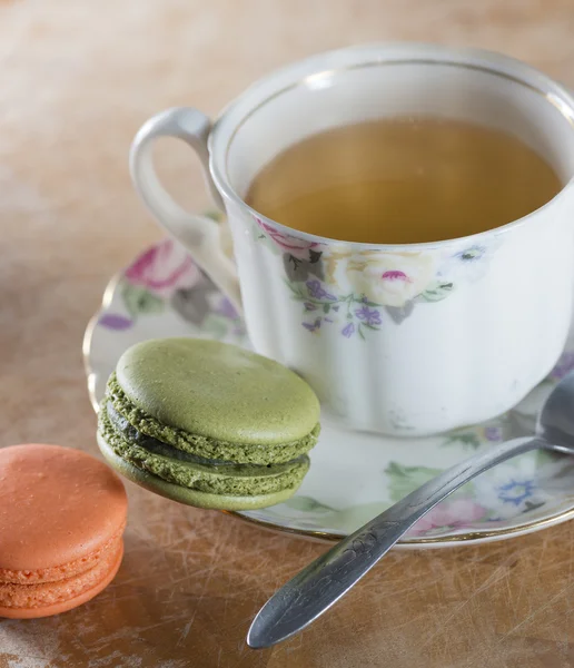 Färgglada franska macaroons och kopp te på träbord, väljande — Stockfoto