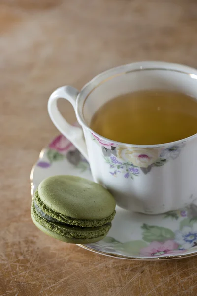 Kolorowe makaroniki francuskie i filiżankę herbaty na drewnianym stole, selecti — Zdjęcie stockowe