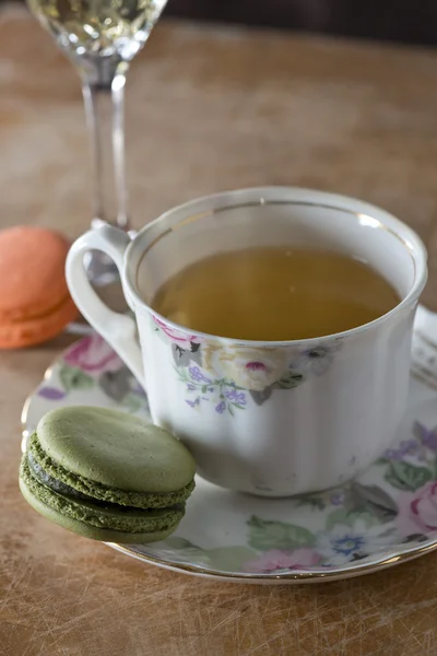 Färgglada franska macaroons och kopp te på träbord, väljande — Stockfoto
