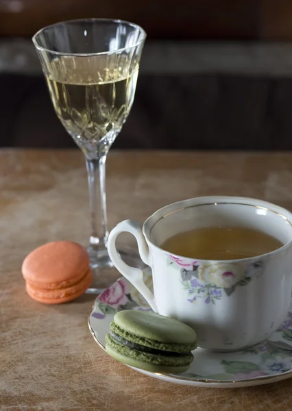 Macaroons franceses coloridos e xícara de chá na mesa de madeira, selecti — Fotografia de Stock