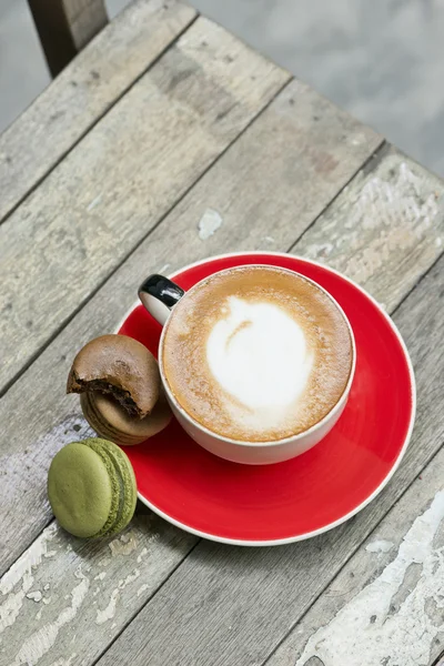 La imagen del café un macarrón sobre una mesa de madera — Foto de Stock