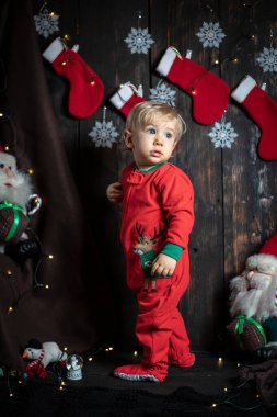 Bebeğin ilk Noel 'i. Noel süslemeleriyle çevrili sevimli bir erkek bebek..