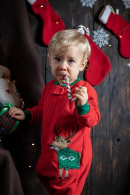 Şeker bastonuyla oynayan tatlı bir erkek bebek. Bebeğin ilk Noel 'i.