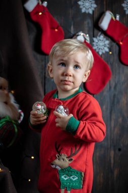Tatlı, sarışın bebek kar küreleriyle oynuyor. Bebeğin ilk Noel 'i.
