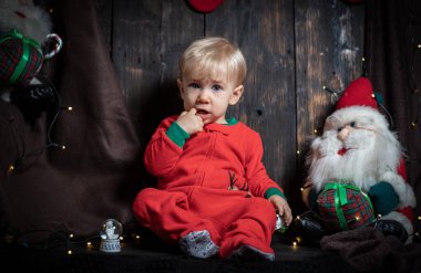 Bebeğin ilk Noel 'i. Noel süslemeleriyle çevrili sevimli bir erkek bebek..