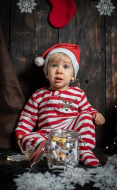 Bebeğin ilk Noel 'i. Noel süslemeleriyle çevrili sevimli bir erkek bebek..