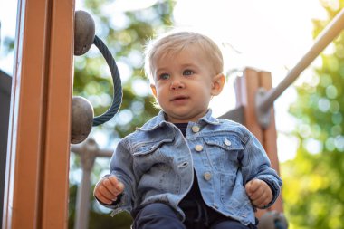 Parkta oynayan küçük sarı saçlı çocuk. Mutlu çocuk..