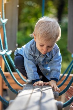 Parkta oynayan küçük sarı saçlı çocuk. Mutlu çocuk..