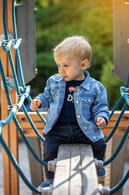 Parkta oynayan küçük sarı saçlı çocuk. Mutlu çocuk..