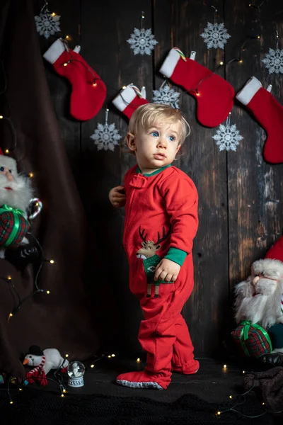 Bebeğin ilk Noel 'i. Noel süslemeleriyle çevrili sevimli bir erkek bebek..