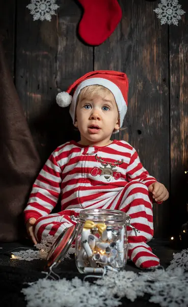 Bebeğin ilk Noel 'i. Noel süslemeleriyle çevrili sevimli bir erkek bebek..