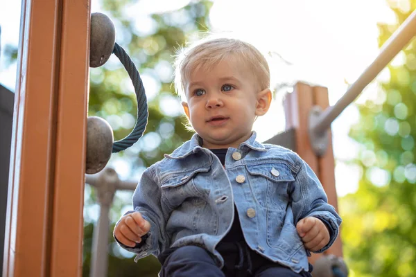 Parkta oynayan küçük sarı saçlı çocuk. Mutlu çocuk..