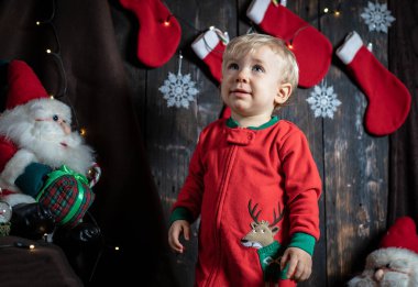 Bebeğin ilk Noel 'i. Noel süslemeleriyle çevrili sevimli bir erkek bebek..