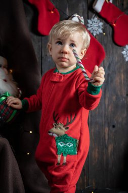 Şeker bastonuyla oynayan tatlı bir erkek bebek. Bebeğin ilk Noel 'i.